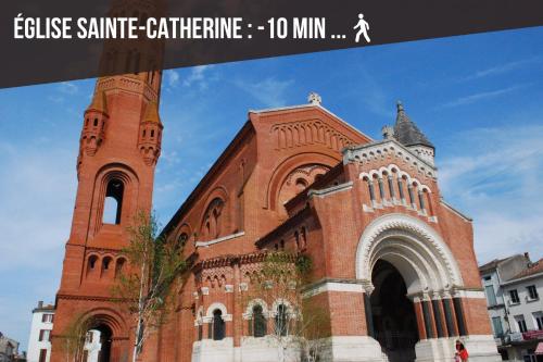 ヴィルヌーヴ・シュル・ロットにあるCinéma Room - Immersion Total pour Cinéphile !の高塔のある大きな赤レンガ教会