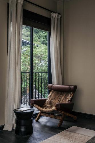a rocking chair sitting in front of a window at Jingdezhen Xingshan City outside Jielu Hotel in Jingdezhen