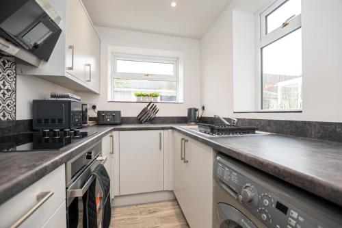 a kitchen with a sink and a dishwasher at Bright Key Stays - The Lincoln Lodge at Spa Street in Lincoln