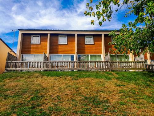 a house with a wooden fence in front of it at VVF Lac d'Eguzon in Éguzon-Chantôme