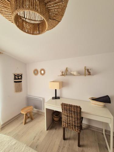 Cette chambre comprend un bureau blanc et une chaise. dans l'établissement Appartement T2, proche plage, climatisé et parking privé, à Saintes-Maries-de-la-Mer
