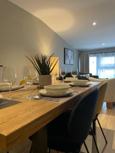 une table de salle à manger avec des verres à vin dessus dans l'établissement COSY SPACIEUX 6 pers Ax Thermes Centre Parking, à Ax-les-Thermes