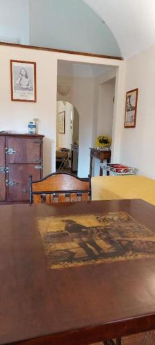 a living room with a wooden table and a bedroom at Oryza Guest House in Desana