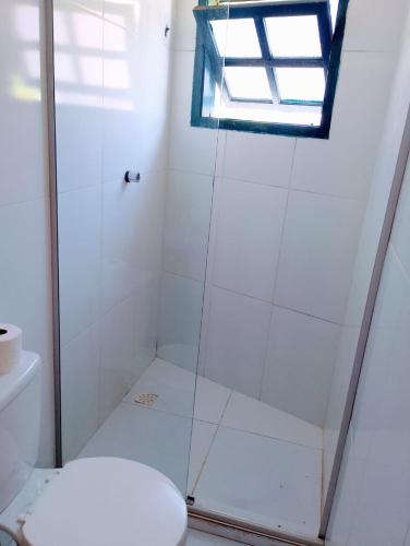 a bathroom with a shower with a toilet and a window at Pousada Brilho da Chapãda in Lençóis