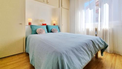 une chambre avec un lit bleu avec deux oreillers dessus dans l'établissement L'Escapade Colmarienne, à Colmar