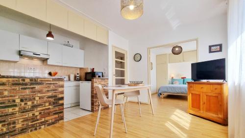 Il comprend une cuisine et un salon avec une table et une télévision. dans l'établissement L'Escapade Colmarienne, à Colmar