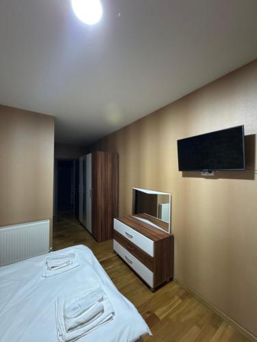 a bedroom with a bed and a flat screen tv at Svaneti in Lentekhi