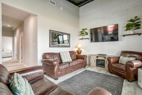 a living room with leather furniture and a flat screen tv at Unique Barn by the Lake in Bridgeport, Texas in Runaway Bay