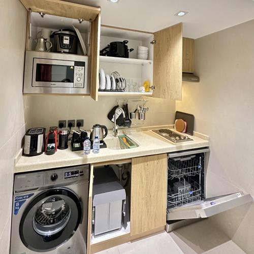 a kitchen with a washing machine and a microwave at Mehad Stay for Self Check-In Apartment in Jeddah