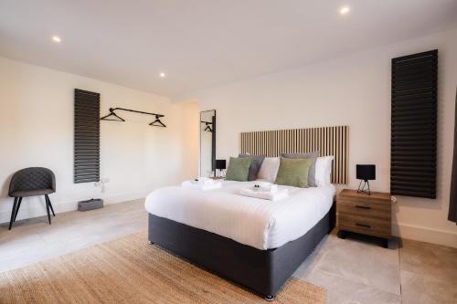 a bedroom with a large bed and a chair at Troed-Y-Rhiw in Llangynwyd