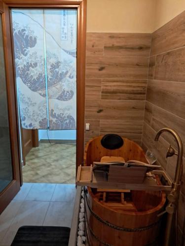 a wooden tub in a bathroom with a shower at Sakura B&B Franciacorta in Cologne
