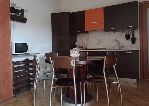 a kitchen with brown cabinets and a table and chairs at Sakura B&B Franciacorta in Cologne