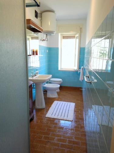 a blue bathroom with a toilet and a sink at La Rosa Bianca in Tornolo