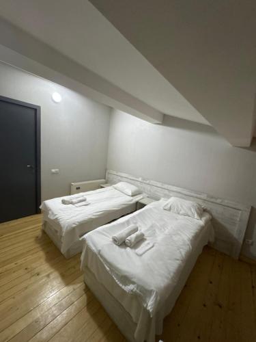 two beds in a room with white sheets at Svaneti in Lentekhi