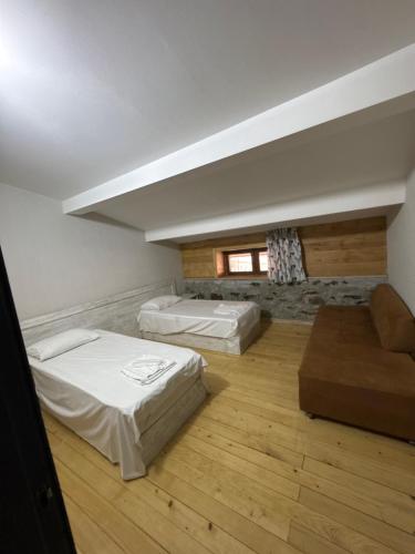 a room with two beds and a couch in it at Svaneti in Lentekhi