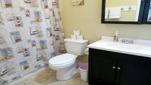 a bathroom with a toilet and a sink and a shower curtain at Steps From Beach! Grill - Wif in Holmes Beach