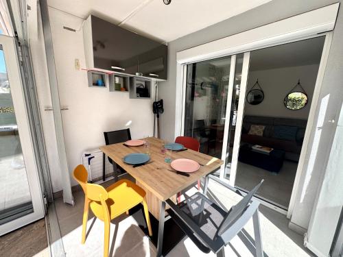 une salle à manger avec une table et des chaises en bois dans l'établissement Appartement - Cap d'Agde, au Cap d'Agde