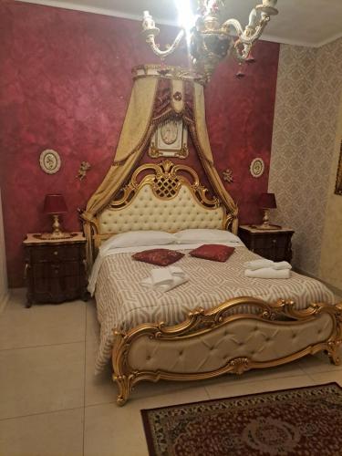 1 dormitorio con 1 cama grande con marco dorado en Luxury House, en Catania