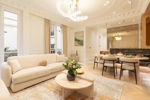 un salon avec un canapé et une table dans l'établissement Maison Galante - Serviced Apartments in Champs-Elysées, à Paris