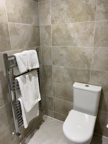 a bathroom with a white toilet and towels at Autumn House in Cambridge