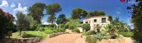 une maison dans un jardin avec un mur en pierre dans l'établissement Enjoy Mougins Villa, à Mougins