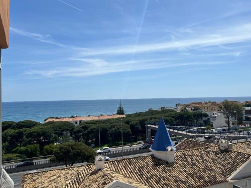 a blue umbrella sitting on top of a roof next to the ocean at Calypso Holidays II in Sitio de Calahonda