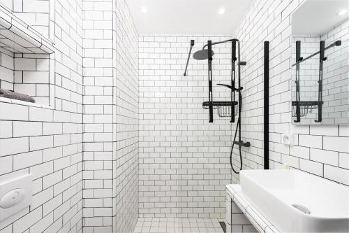 a white bathroom with a shower and a sink at Palais athenea in Beausoleil