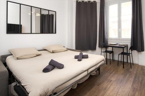 a bedroom with a bed with two pillows on it at Palais athenea in Beausoleil