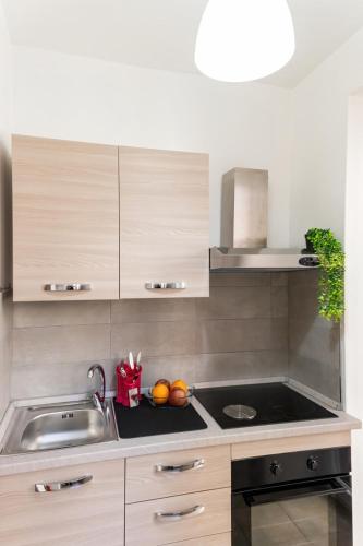 a kitchen with a sink and a counter with fruit on it at Casa Glow Isernia - privacy, wi-fi, colazione in Isernia
