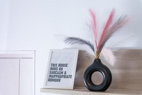 a black vase sitting on a shelf next to a sign at Casa Glow Isernia - privacy, wi-fi, colazione in Isernia