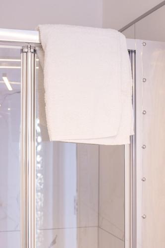 a towel hanging on a shower curtain in a bathroom at Casa Glow Isernia - privacy, wi-fi, colazione in Isernia