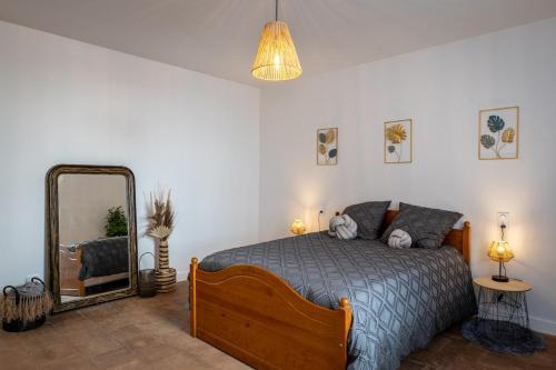 une chambre avec un lit et un grand miroir dans l'établissement Au Paradis Des Anges maison de village climatisé avec jardin, à Briatexte