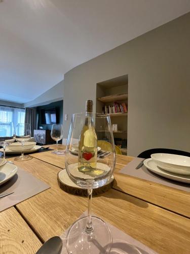 - un verre de vin assis au-dessus d'une table en bois dans l'établissement GRAND COSY 10-12 pers Ax Thermes Centre Terrasse Parking, à Ax-les-Thermes