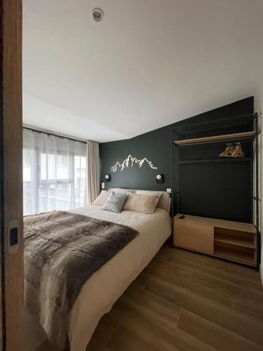 - une chambre avec un grand lit et un mur noir dans l'établissement GRAND COSY 10-12 pers Ax Thermes Centre Terrasse Parking, à Ax-les-Thermes