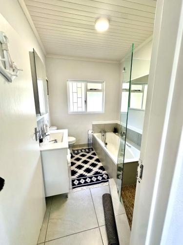 a bathroom with a tub and a sink and a shower at Pletts Seaside Gem in Plettenberg Bay