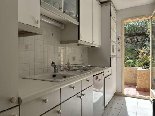 une cuisine avec des armoires blanches et un évier dans l'établissement Maison 4 couchages - BANYULS SUR MER BN040-008, à Banyuls-sur-Mer