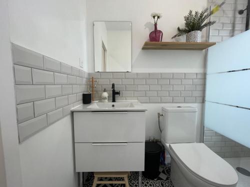 a white bathroom with a toilet and a sink at Bosco in Valence