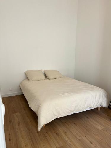 Ce lit se trouve dans un dortoir doté de murs blancs et de parquet. dans l'établissement Beautiful cozy apartment, à Paris