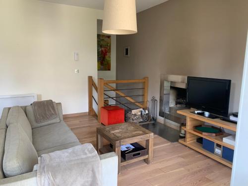 un salon avec un canapé et une télévision dans l'établissement Appartement Deauville, à Deauville