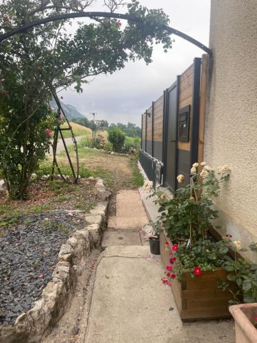 a path next to a building with flowers next to it at Domaine de Chevigneux in Chindrieux