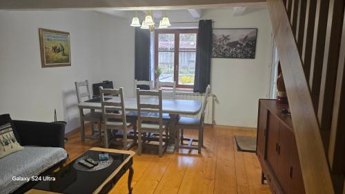 a living room with a dining room table and chairs at le refuge des sapins in Provenchères-sur-Fave