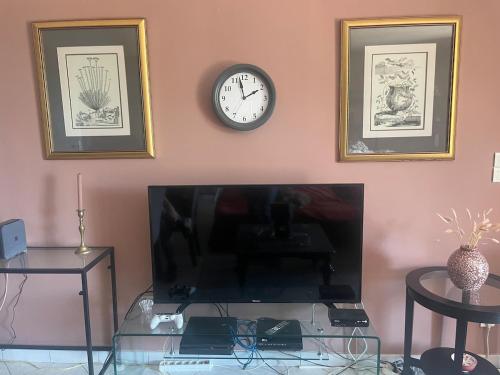 a room with a tv and a clock on a wall at Domaine de Chevigneux in Chindrieux