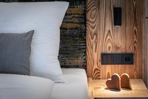 a bedroom with a bed with a speaker on a wooden wall at Steindlgut - Weinberg Chalets in Brixen