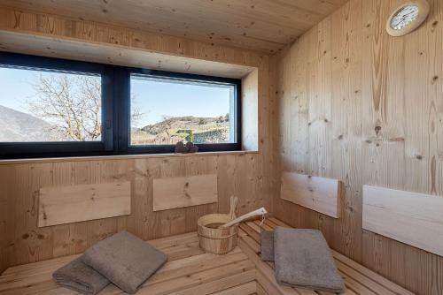 a wooden room with a tub and a window at Steindlgut - Weinberg Chalets in Brixen