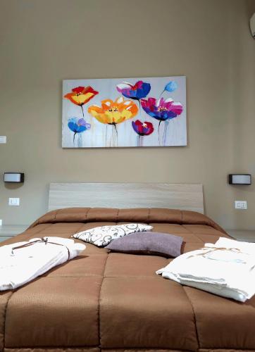 a bed with two pillows and a painting on the wall at Calabrese Family in Pompei