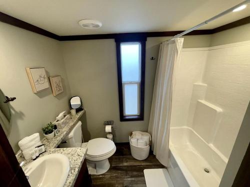 a bathroom with a toilet and a sink and a shower at Breathtaking Tiny House Settled Between Trees in Tracy City, Tennessee in Tracy City