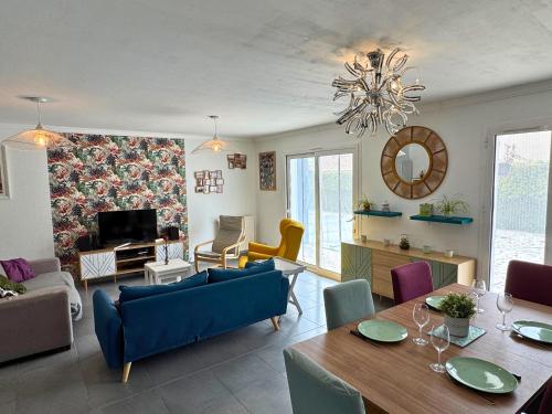 un salon avec une table et des chaises et une salle à manger dans l'établissement Lotus - Terrasse - Piscine - Parking, à Dax