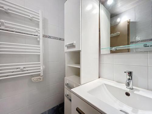 une salle de bain blanche avec un lavabo et un miroir dans l'établissement 3683-Appartement en front de mer, à Saint Cyprien Plage