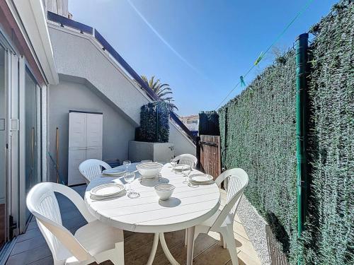 d'une table et de chaises blanches sur un balcon. dans l'établissement 3683-Appartement en front de mer, à Saint Cyprien Plage