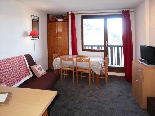 d'un salon avec une table et un balcon. dans l'établissement Studio pour 4 pers. aux Orres 1650, accès direct pistes - FR-1-322-551, aux Orres